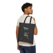 Model carrying a black cotton canvas tote bag with a sea turtle design and 'Aquatic Views' text. Stylish and functional.